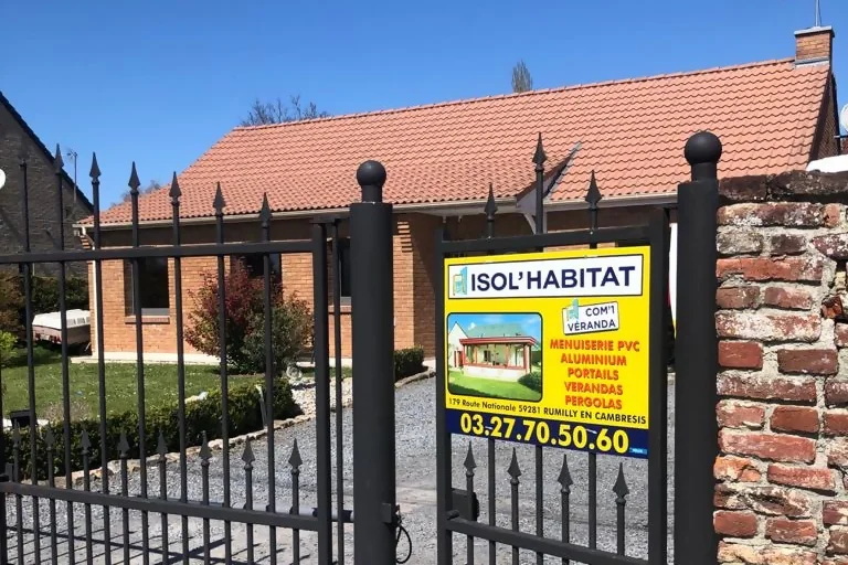 Isol'Habitat Cambrai : Réalisations de menuiseries, vérandas et pergolas vue d'une façade de maison avec la pancarte de réalisation de chantier Isol Habitat Cambrai