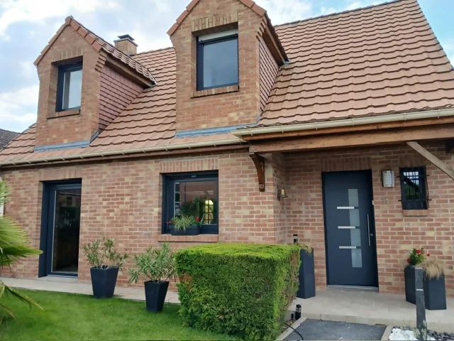 Pose de menuiseries PVC à Proville vue de la façade d'une maison à Proville avec les menuiseries PVC gamme REFERENCE posées par ISOL'HABITAT