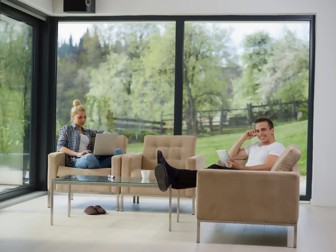 vue d'un couple dans un salon équipé de baie vitrée aluminium
